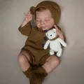 Realistic 49cm reborn baby doll April wearing brown knit outfit with small bear toy - Full Silicone Boy