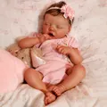 Realistic 18-inch reborn baby doll in pink floral outfit sleeping on a soft cushion - 18 inch / Cloth Body