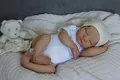 Close-up of lifelike 19 inch reborn doll with 3D skin texture and white knit set - Cloth Body Style