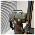 Detail of dark green barrel bag with gold rivets and bohemian woven wide shoulder strap - Green
