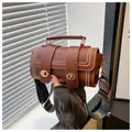 Detailed shot of a vintage brown cylindrical handbag with decorative wavy edge stitching - Brown