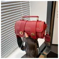 Detail of red cylinder bag featuring gold twist locks and bohemian printed strap - Red