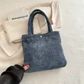 Deep blue textured woven tote bag with golden metal buckle and corduroy finish - Blue