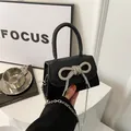 Black sequin crossbody bag with a sparkling rhinestone bow and silver chain strap - Black