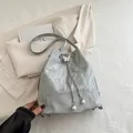 Bolso saco plateado con textura plisada, colgante de mariposa y cordón de perlas - Plateado