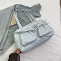Hellblaue glänzende Ledertasche mit Schleifenakzenten und zwei Fronttaschen - Blau