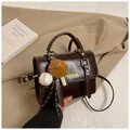 Detailed macro of vintage dark brown faux leather bag with baseball themed pendants - Coffee with Pendant