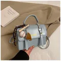 Detail of light blue crossbody bag with unique baseball bat and glove keychain charm - Blue with Charm
