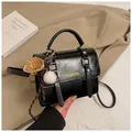 Detail of black glossy leather crossbody bag with gold hardware and fashion lettering - Black With Pendant