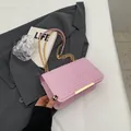 Chic pink quilted crossbody bag featuring a golden metal bar and elegant chain strap - Pink