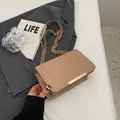 Beige V-quilted square crossbody bag with gold chain strap on a blazer background - Khaki
