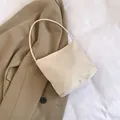 Creamy beige bucket bag with 'pretty and liberty' embroidery on a chic blazer background - White