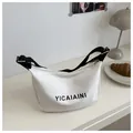 Détail du sac demi-lune en toile blanche avec bandoulière noire et boucles dorées - Blanc
