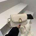 Minimalist cream white saddle crossbody bag with a vintage gold horseshoe buckle closure - White