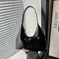 Glänzende schwarze Lackleder-Hobo-Tasche mit silbernem Logo und modernem Design - Schwarz