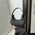 Schicke schwarze Mini-Halbmondtasche mit Litschi-Textur und goldenen Details - Schwarz