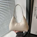 Schicke beige Hobo-Tasche aus glänzendem Lackleder mit Tragegriff und dezentem Logo - Weiß