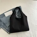 Minimalistische schwarze Canvas-Einkaufstasche mit Jeansjacke und Büchern dekoriert - Schwarz