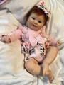 Detailed view of 50cm realistic reborn baby doll Maddie with blue eyes and floral pink dress - Cloth Body Style / 50 cm