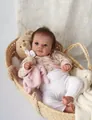 Detailed view of 19-inch lifelike reborn doll in a woven basket with a plush bear - Cloth Body / Exquisite Painted