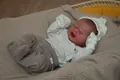Vue détaillée d'une poupée Reborn réaliste qui pleure, avec des vêtements en tricot - Style Yeux Fermés Pleurs / 49cm
