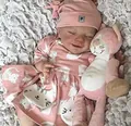 Detailed view of sleeping reborn doll in pink cat outfit with a matching plush toy - Full Body Boy