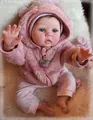 Close-up of 55cm reborn baby doll wearing a pink bear-ear plush coat on soft white rug - Pink Bear Hooded Outfit / Pink / 55cm