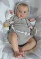 Detail of reborn doll wearing gray knit outfit and baby beaded pacifier chain - 48cm Cloth Body