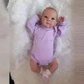 Realistic 18-inch reborn baby doll Bettie in purple romper on soft white plush rug - 18 Inch Full Silicone Doll / Purple (As Shown)