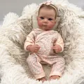 Lifelike 18-inch reborn baby doll in pink floral romper on white plush background - Pink Floral Style