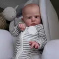 Lebensechte 60cm Reborn-Puppe Cameron in gestreiftem Outfit auf weißen Kissen liegend - Einheitsgröße / Schwarz-Weiß gestreifter Stil