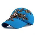 Dettaglio ravvicinato di ricami floreali dorati e strass colorati su un cappello blu navy - Regolabile / Blu