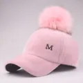 Close-up of pink plush baseball cap with fuzzy pompom and silver metal letter M - Adjustable / Pink (6-Panel Pink Pom-pom Snap Style) / Kids