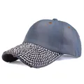 Detail of dark blue denim baseball cap with silver rivets and distressed brim design - Adjustable / Light Washed Denim
