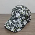 Dettaglio ravvicinato di un cappello da baseball nero con motivo floreale bianco su legno - Motivo Floreale Nero Bianco (Stile 7)