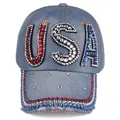 Detailed close-up of USA rhinestone letters on washed blue denim baseball cap surface - Light Blue Denim