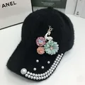 Detail of plush baseball cap with floral decor, gold deer, and pearl embellishments - Adjustable / Black
