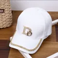 Détail d'une casquette blanche en coton avec logo DB et ornements en strass brillants - Réglable / Blanc