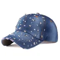 Detailed macro of denim baseball cap featuring silver star studs and distressed brim detail - Denim Blue