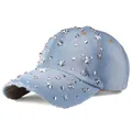 Detail view of light blue denim baseball cap featuring silver star studs and frayed brim - Denim No. 2 (Light Blue)