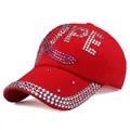Detail van fonkelende HOPE-letters en roze lintje op een rode katoenen baseballpet - Verstelbaar / Rood