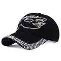 Detailed view of black suede baseball cap with shimmering silver rhinestone wing pattern - Black