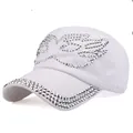 Close-up of white cotton baseball cap featuring intricate silver rhinestone bird pattern - White