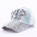 Detailed close-up of glittering VIP letters and rhinestones on the denim baseball cap - Clear Rhinestone Denim 1