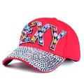 Close-up of sparkling SEXY letter rhinestones and crystals on a red baseball cap - Adjustable / Red