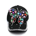 Black baseball cap featuring large colorful rhinestone butterfly design and embellished brim - Black