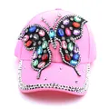Gros plan d'une casquette rose avec un grand papillon en strass multicolores - Rose