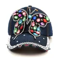 Détail d'une casquette en jean bleu avec papillon en strass colorés et ornements bijoux - Denim Bleu Foncé