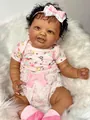 Close-up of a 60cm reborn doll with realistic deep skin texture and curly black hair - Pink Floral Dress Deep Skin Style