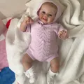 Lifelike 48cm reborn baby doll wearing a purple knit romper on a soft white plush rug - Pink Purple / 48cm Cloth Body